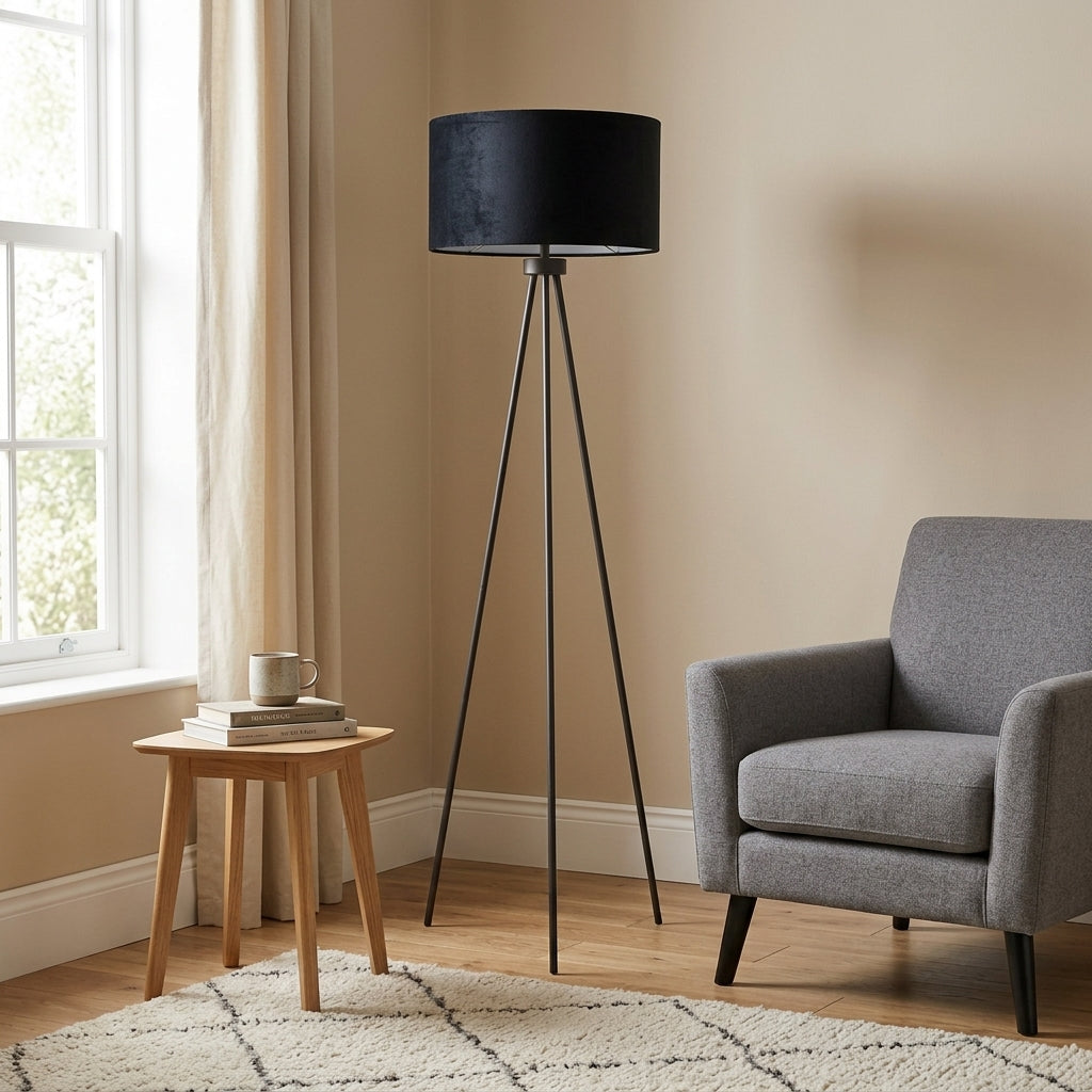 Black tripod floor lamp in a small modern living room — clean matt black legs with white shade, architectural statement piece in compact UK living space